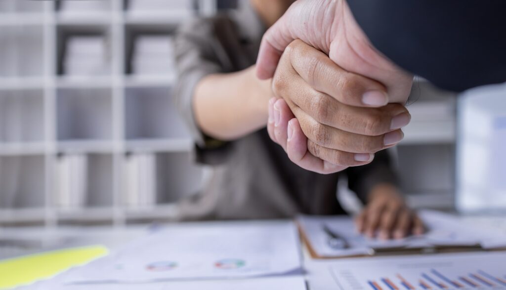 Handshake of businesspeople. Female and male hand makes a handshake in the office.
